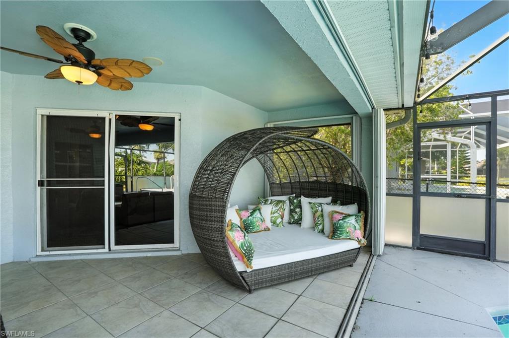 Outdoor living space with canopy bed and ceiling fan