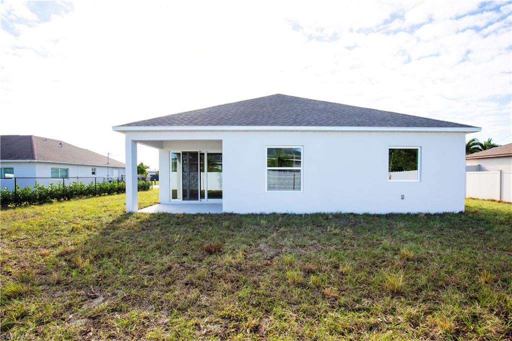 Rear view of property with a patio, stucco siding, and a shingled roof