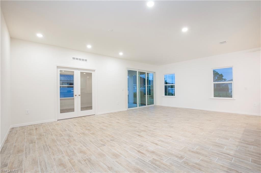 Unfurnished room featuring wood finish floors, french doors, and recessed lighting