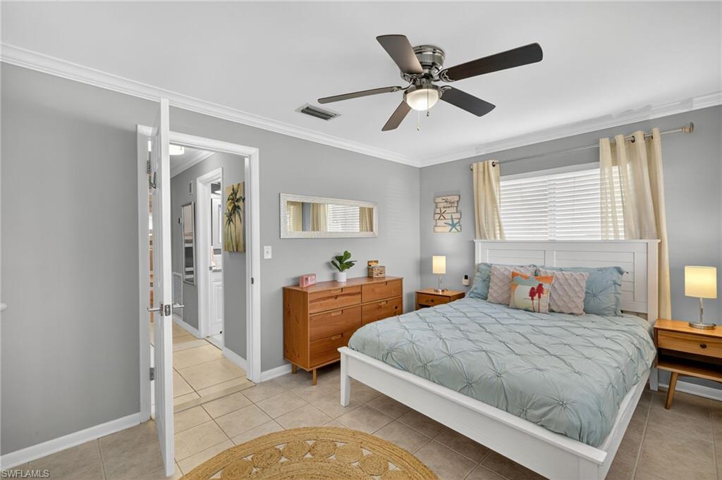 Tiled bedroom featuring crown molding and a ceiling fan