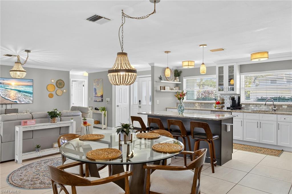 Dining area with ornamental molding and light tile patterned flooring