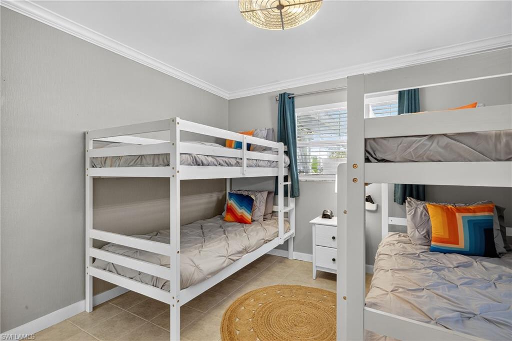 Bedroom featuring crown molding and light tile patterned floors