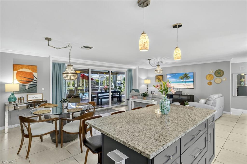 Kitchen with decorative backsplash, appliances with stainless steel finishes, white cabinetry, light tile patterned flooring, and crown molding