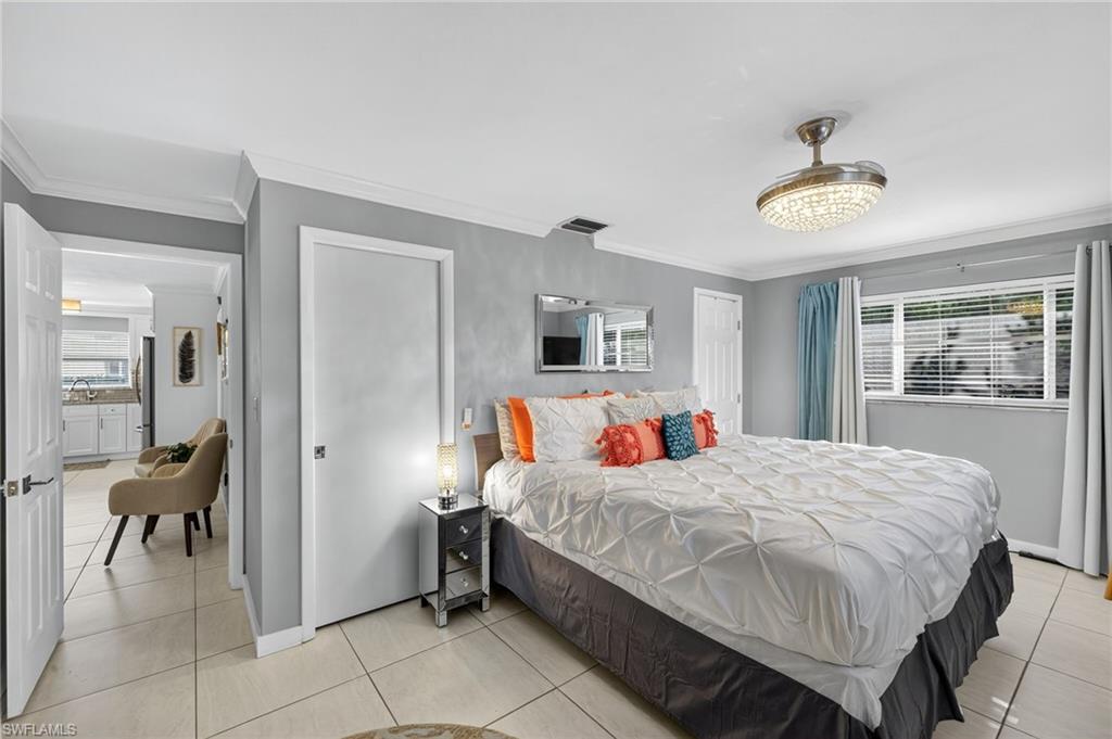 Bedroom featuring crown molding and light tile patterned floors