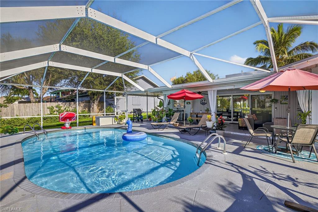 Outdoor pool with a boat dock, a water view, boat lift