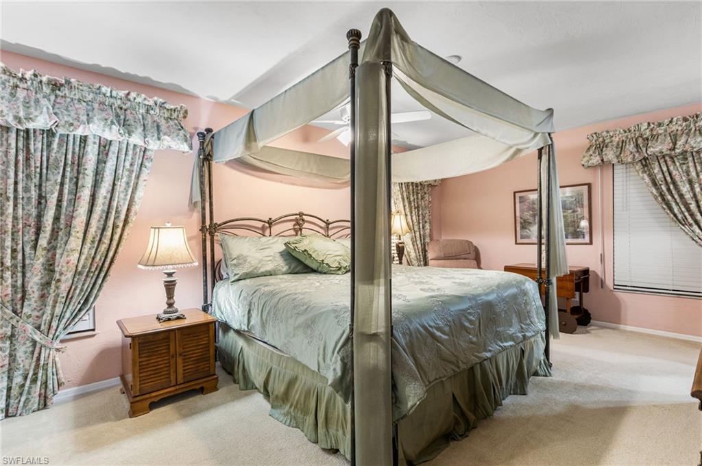 Carpeted bedroom with baseboards and a ceiling fan