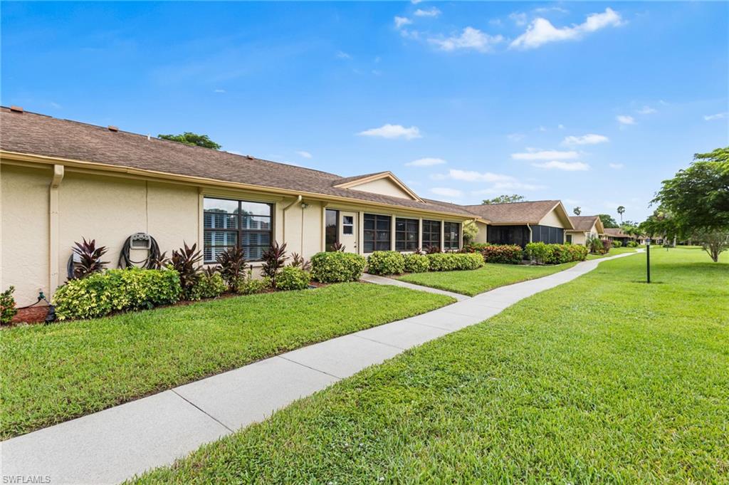 View of front of property with stucco siding and a front lawn