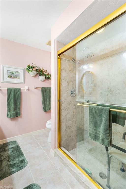 Bathroom featuring a shower stall and tile patterned flooring