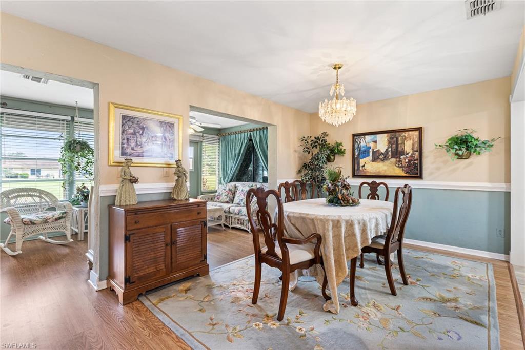 Dining space with wood finished floors and a chandelier