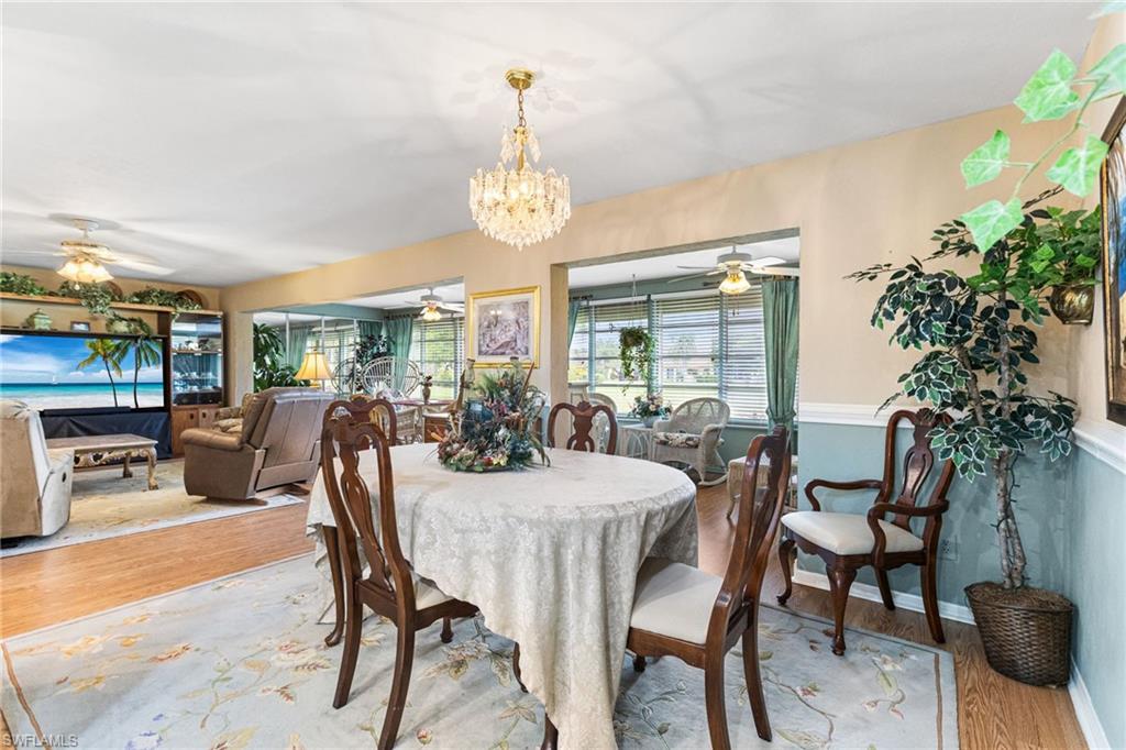 Dining room featuring wood finished floors, ceiling fan, and a chandelier