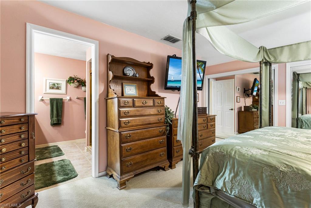 Bedroom with light colored carpet and ensuite bath