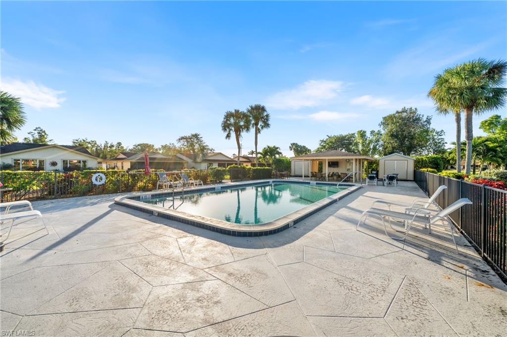 Community pool with a patio area and an outdoor structure