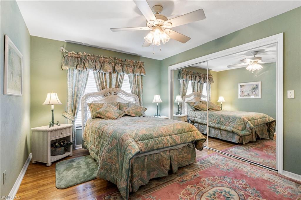 Bedroom featuring multiple windows, wood finished floors, a closet, and a ceiling fan