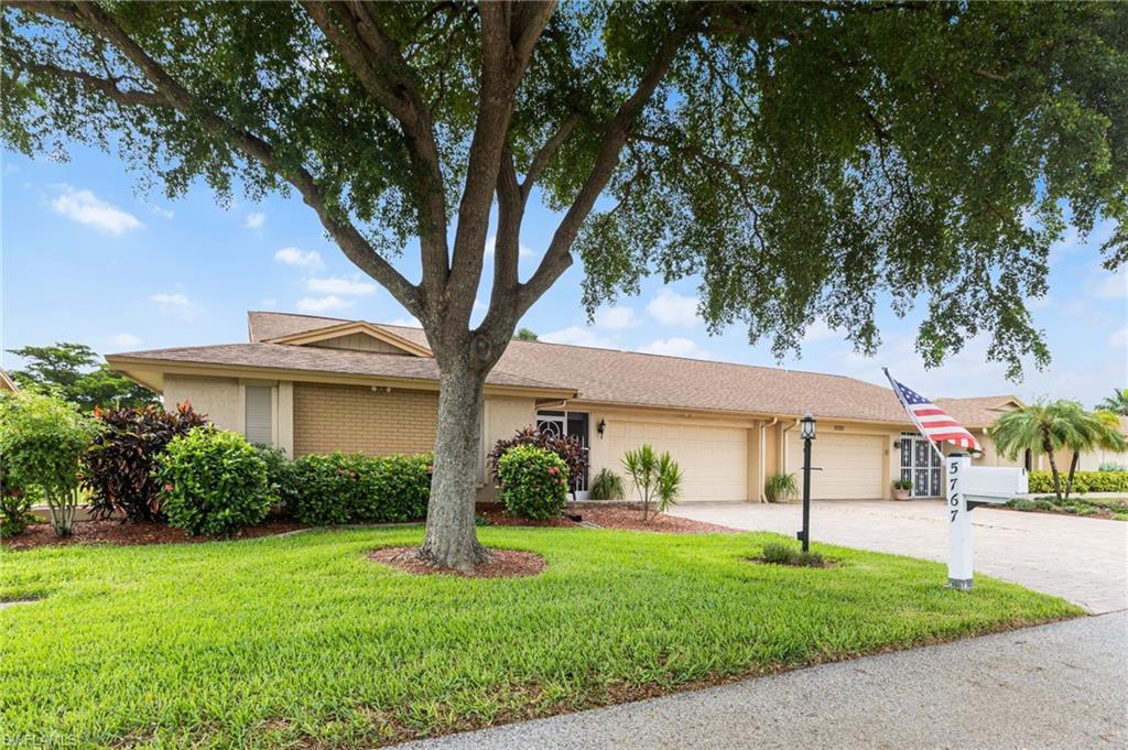 Ranch-style house with a front yard, an attached garage, decorative driveway, stucco siding, and a shingled roof