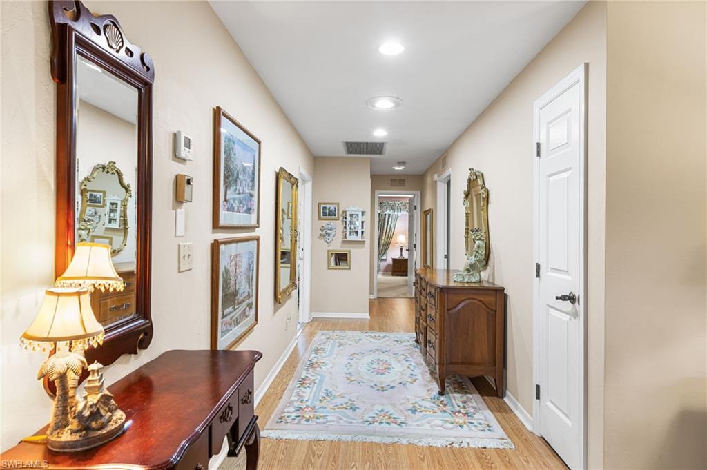 Corridor with light wood-style flooring and recessed lighting