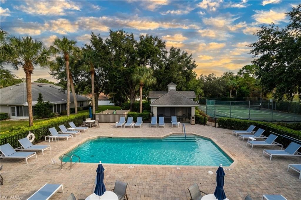 Community pool with a patio and view of scattered trees
