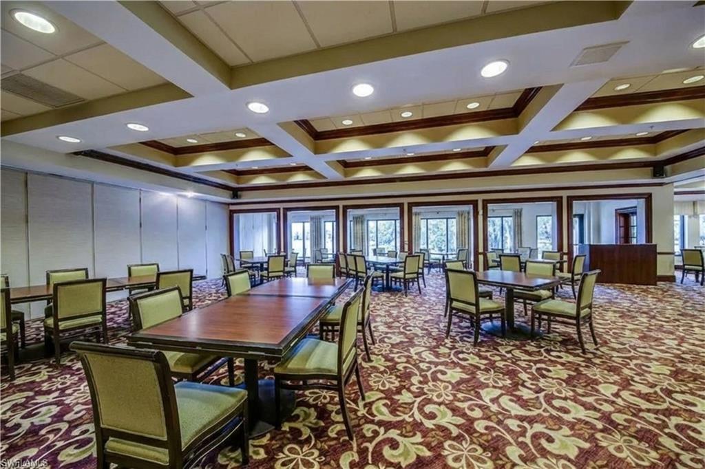 Dining room with carpet floors, a decorative wall, coffered ceiling, and beam ceiling