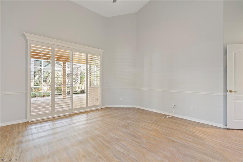 Empty room with a high ceiling and light wood-style flooring