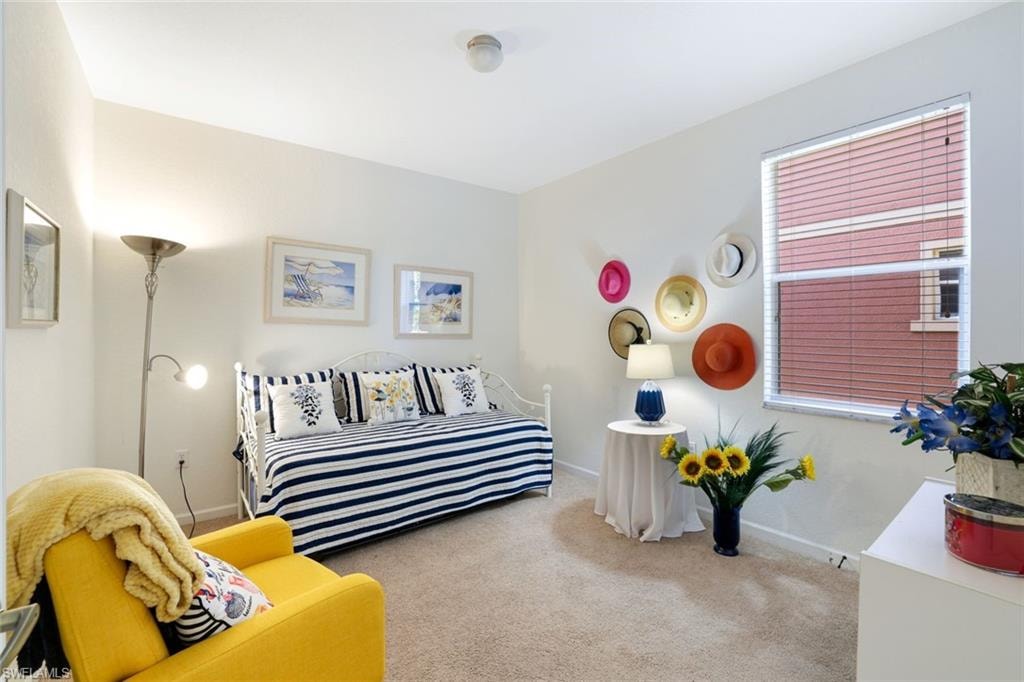 Bedroom featuring carpet and baseboards
