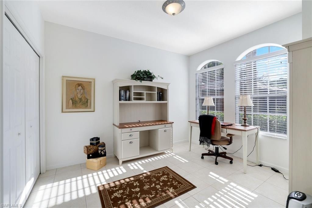 Office area featuring light tile patterned floors and baseboards