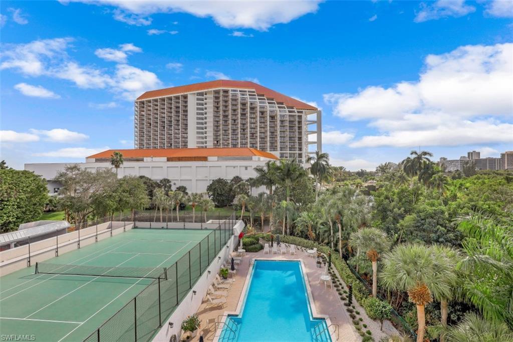 View of pool featuring tennis court