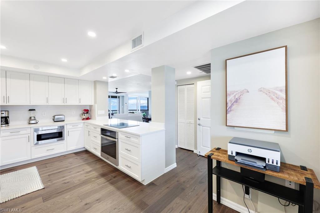 Kitchen featuring white cabinets, wood-type flooring, and appliances with stainless steel finishes