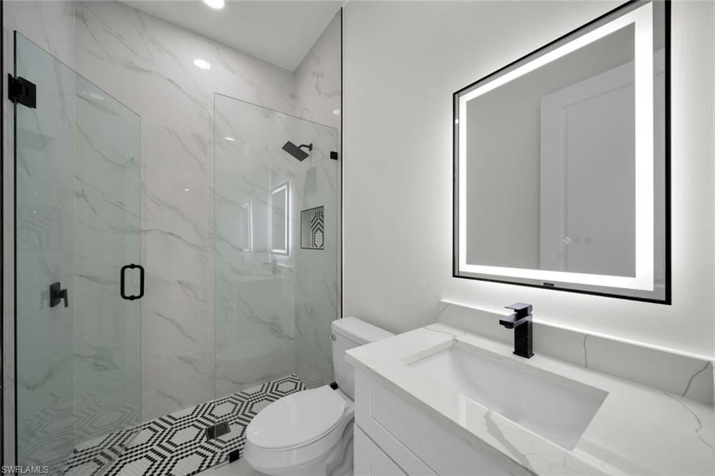 Full bathroom featuring recessed lighting, vanity, and a marble finish shower