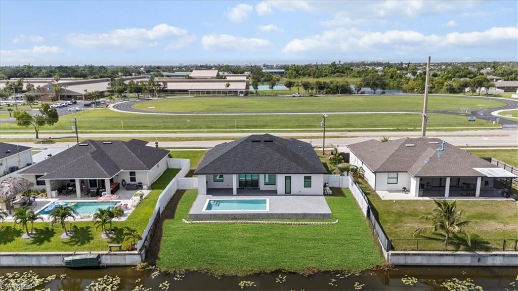 Aerial view of residential area featuring a large body of water and a pool area