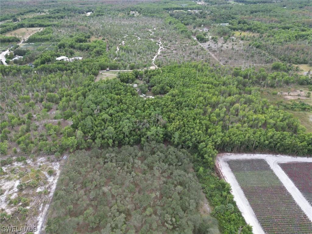 Aerial view of property and surrounding area featuring a heavily wooded area