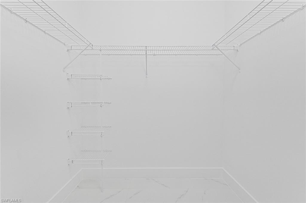 Spacious closet featuring marble look tile flooring