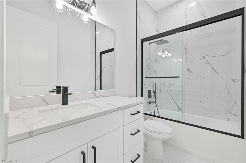 Bathroom featuring enclosed tub / shower combo and vanity