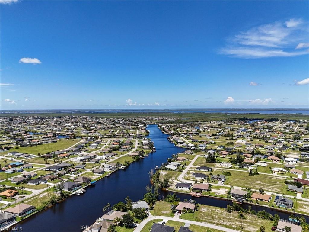 Aerial view of residential area featuring a nearby body of water