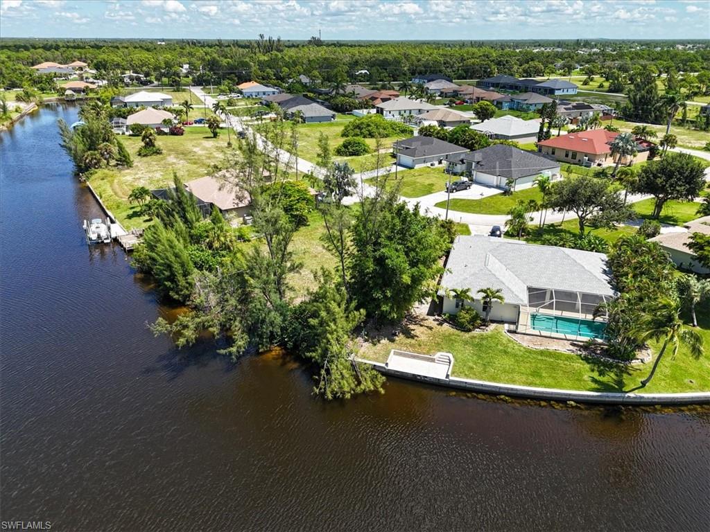 Aerial perspective of suburban area featuring a large body of water and a pool area