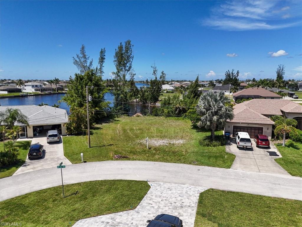 View of property's community with a residential view, a water view, and a lawn