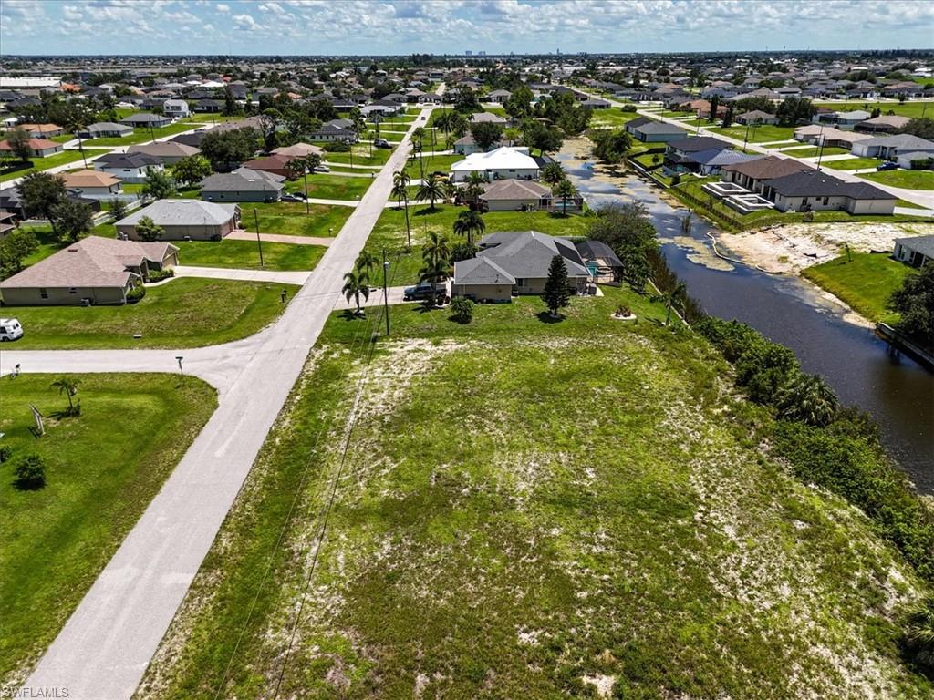 Aerial perspective of suburban area featuring a nearby body of water