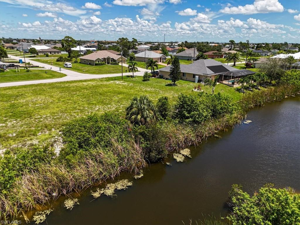 Aerial perspective of suburban area featuring a nearby body of water
