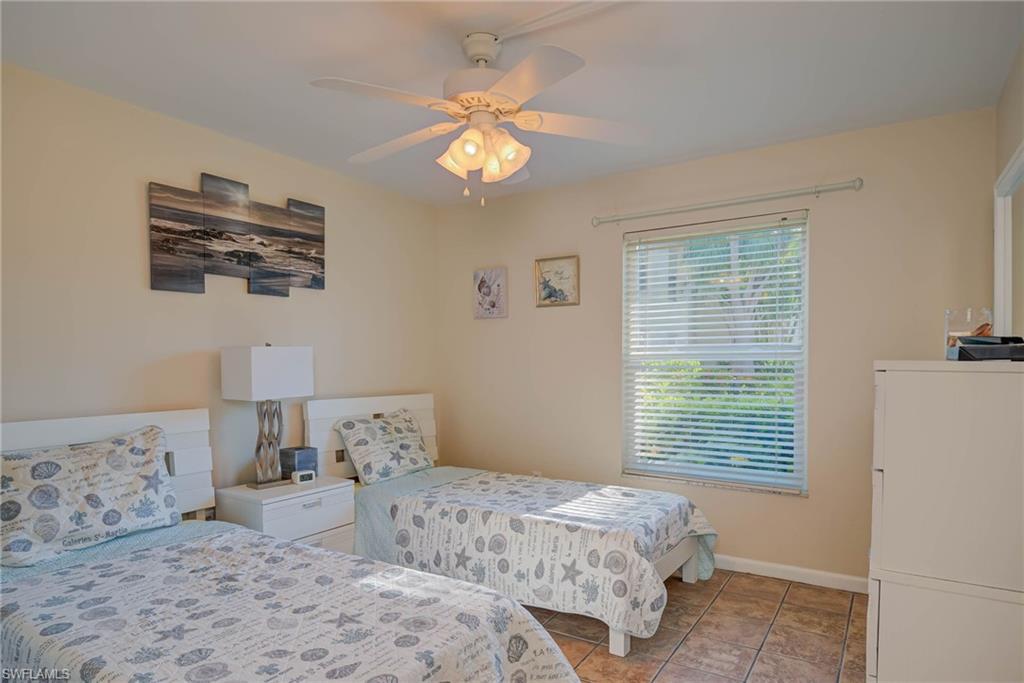Bedroom with ceiling fan and light tile patterned flooring