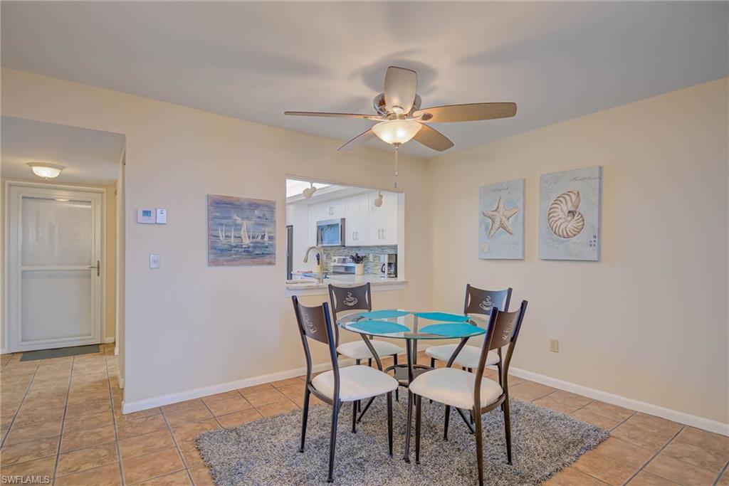 Dining space with light tile patterned floors and a ceiling fan
