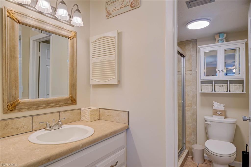 Bathroom featuring a shower stall, vanity, and light tile patterned floors