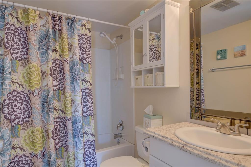 Full bath with shower / tub combo with curtain and vanity