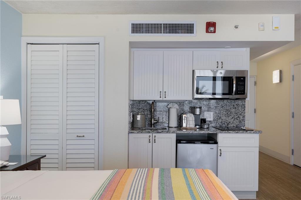 Kitchenette featuring microwave, flat stovetop, coffee maker & refrigerator
