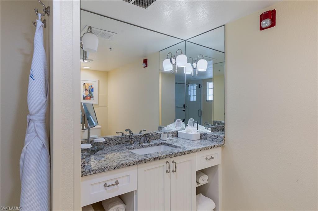 Bathroom with dual sink vanity and ample storage.