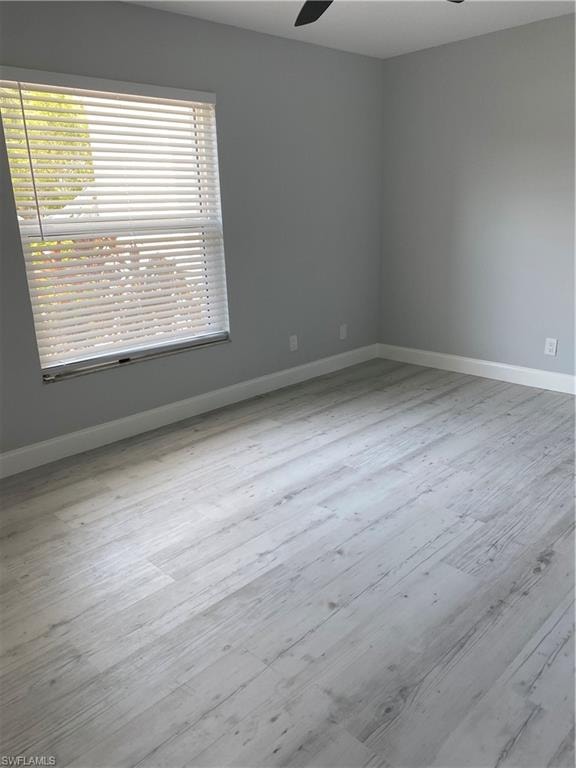 Unfurnished room with light wood finished floors and ceiling fan