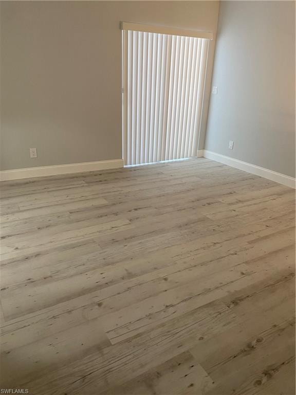 Unfurnished room featuring wood finished floors and baseboards