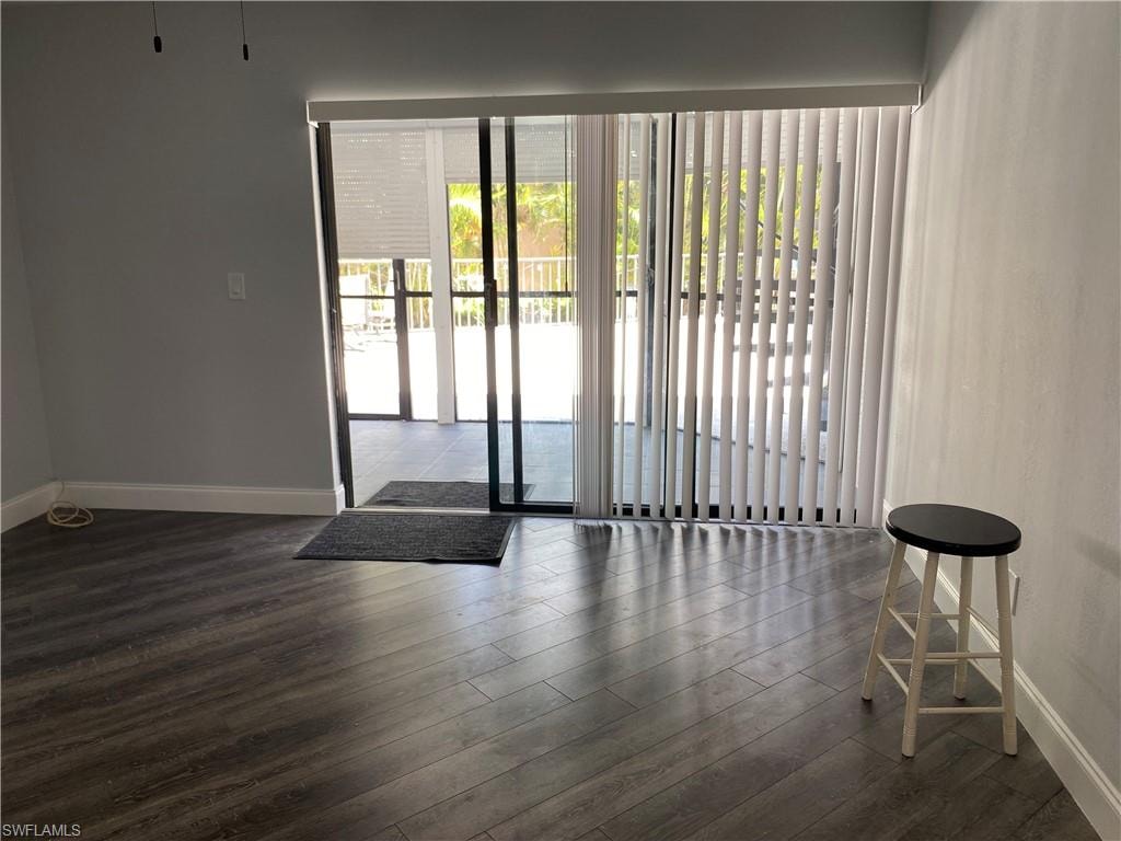Doorway to outside featuring baseboards and wood finished floors