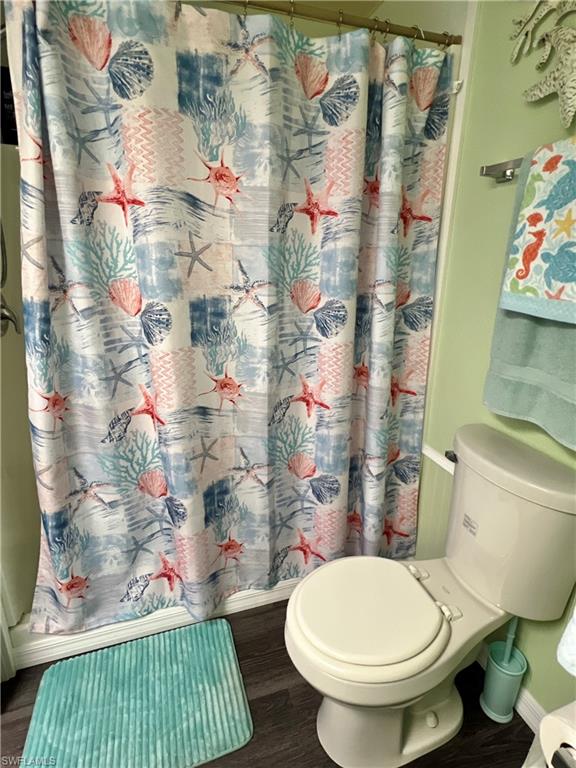 Bathroom with wood finished floors and curtained shower
