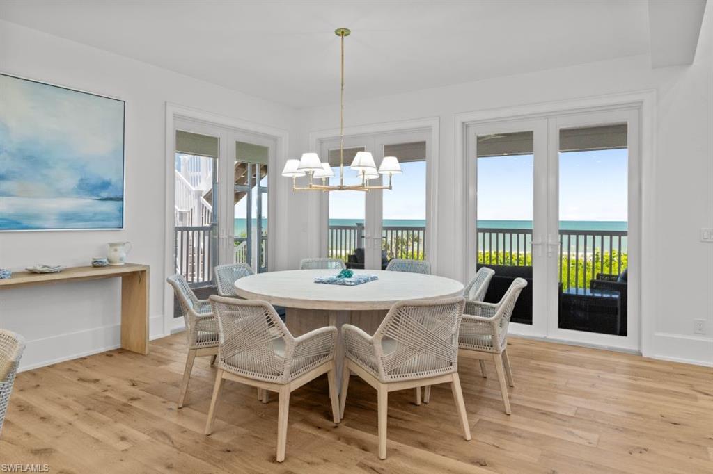 Dining room featuring a water view, light wood-style floors, and a chandelier