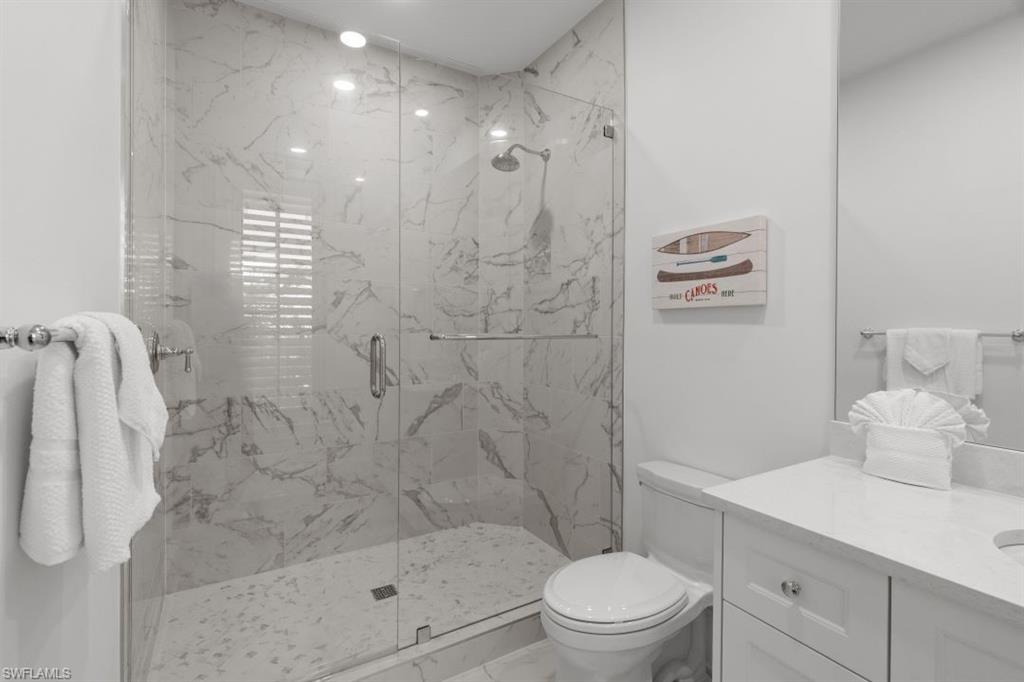 Bathroom with a marble finish shower, vanity, and marble finish flooring