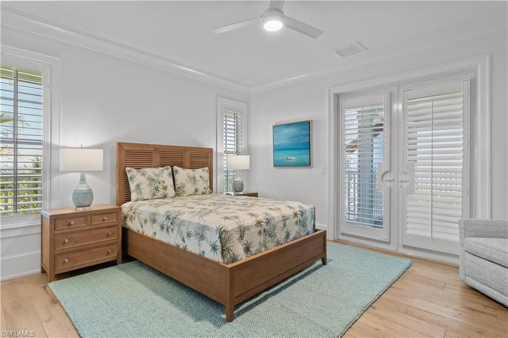 Bedroom with crown molding, light wood finished floors, access to exterior, and ceiling fan