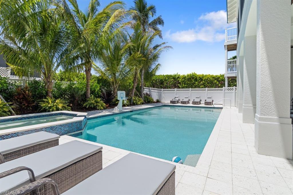 View of swimming pool with a fenced backyard, a patio area, and a pool with connected hot tub